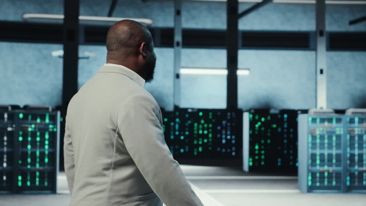 Vertical video Employee walking in high tech data center with hardware used to host websites
