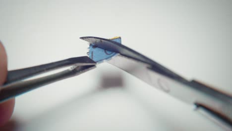 4k macro shot of scissors cutting a tab of lsd in half for microdosing