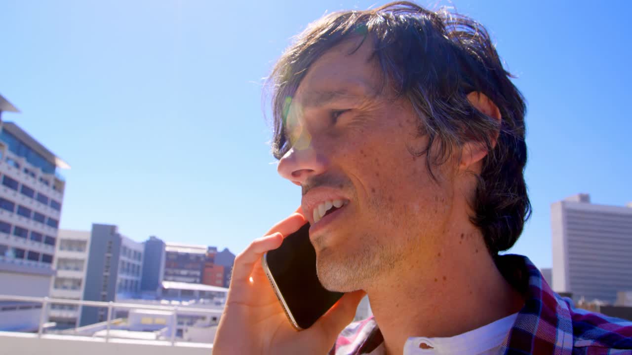 테라스 4k에서 휴대 전화로 이야기하는 남성 사진작가