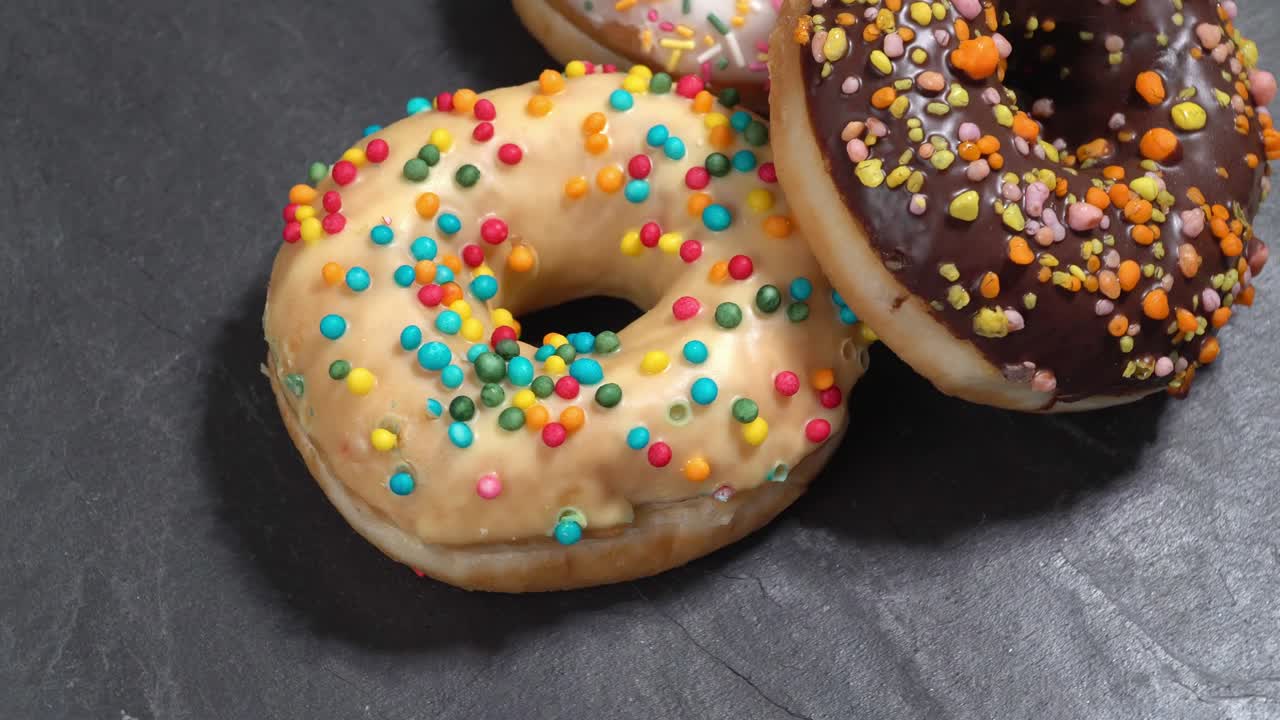 rosquillas dulces girando sobre un fondo oscuro. dulzura tradicional estadounidense