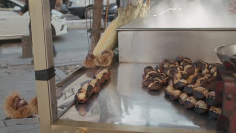 street food vendor with delicious roasted and cooked chestnuts, prepared, served and ready to eat on stall