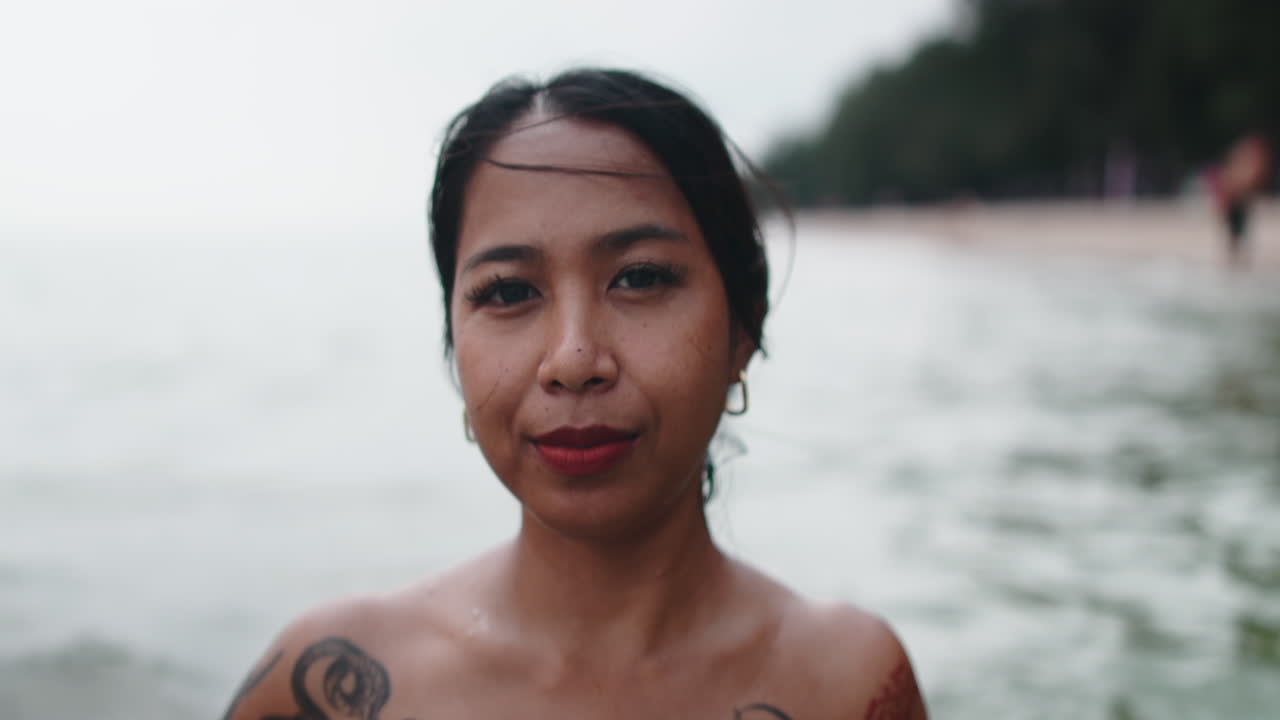 Portrait of a tattooed woman at the beach