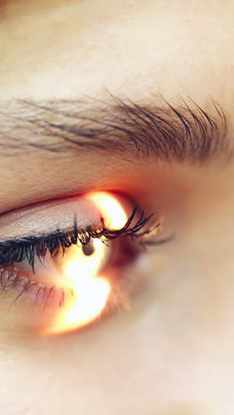 eyes examination. close-up woman's eyes checking by a doctor. laser shining inside the eye. eyesight concept. vertical video