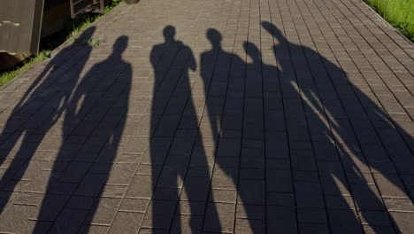 shadows of people on a pavement