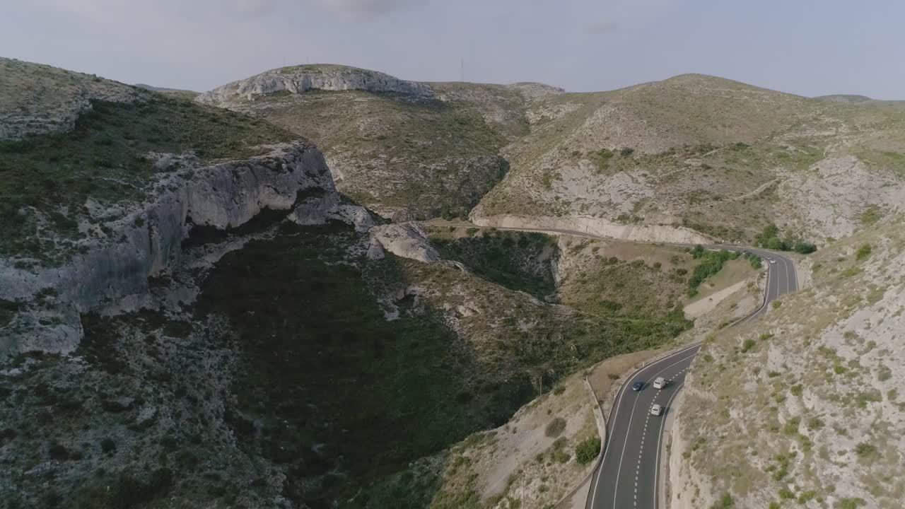 Aerial view of a valley road with vehicles at sunrise