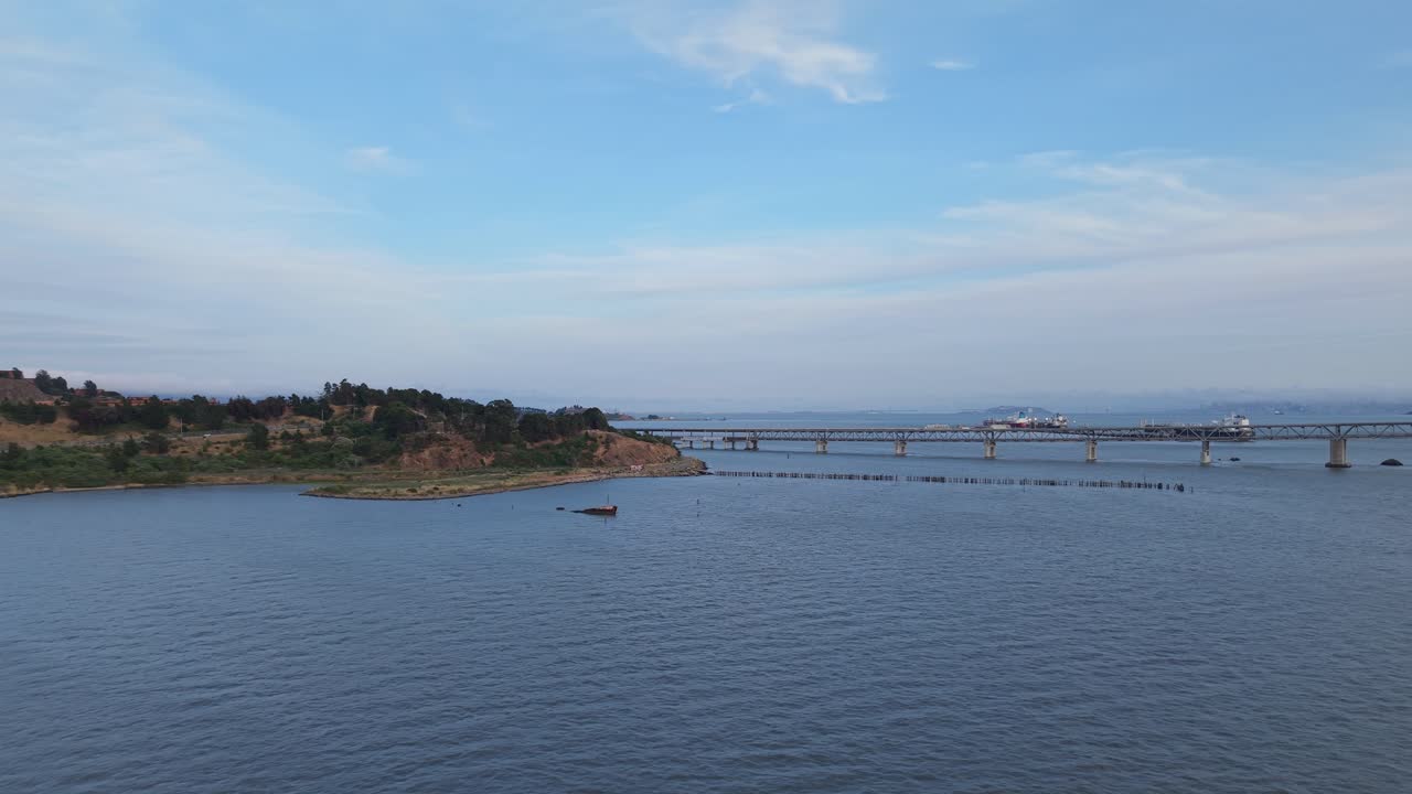 A wide aerial shot reveals the rugged beauty of Point Molate’s beach surrounded by rolling terrain and bay views.