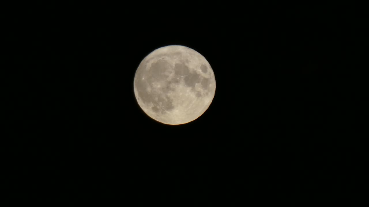 Close-up da superfície craterada da lua cheia da colheita passando pelo céu noturno escuro
