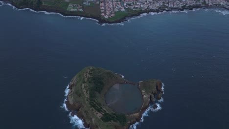 Reveal-shot-of-Ilhéu-de-Vila-Franca-do-Campo-with-Vila-Franca-do-Campo-city-in-background,-aerial