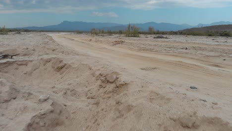 Establishing-drone-shot-of-dirt-road-and-mountains-in-rural-Mexico