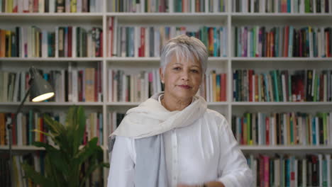 portrait of friendly indian middle aged  teacher looking at watch standing in library waiting