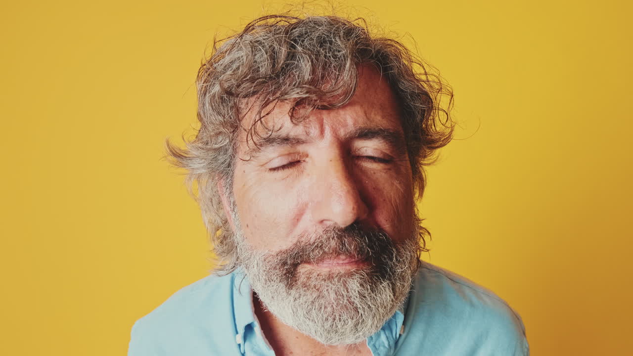 Middle-Aged Man with Beard and Curly Hair Looking at Camera