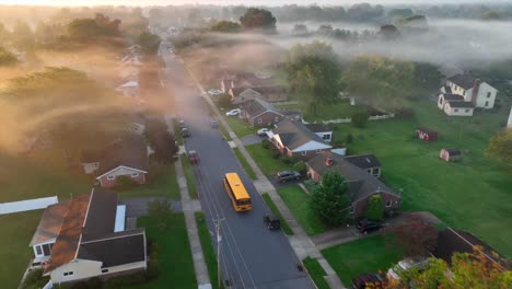 Yellow-school-bus-driving-through-residential-neighborhood-at-sunrise