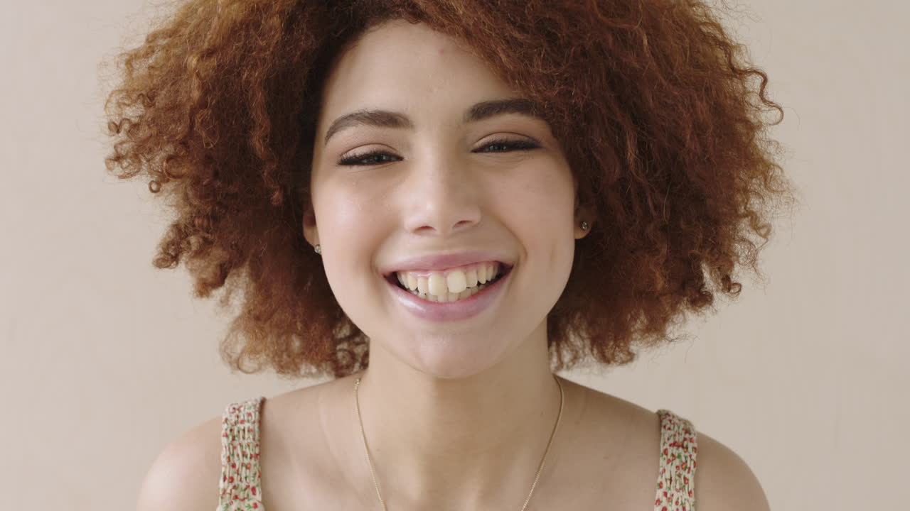 retrato de cerca mujer estudiante con afro riendo feliz alegre