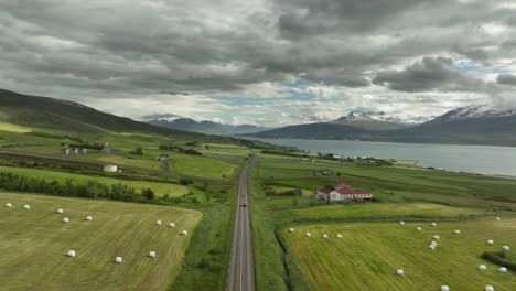 Landschaft-Mit-Bergen-Und-Grasland-Mit-Bauernhaus-Luftaufnahme-Island