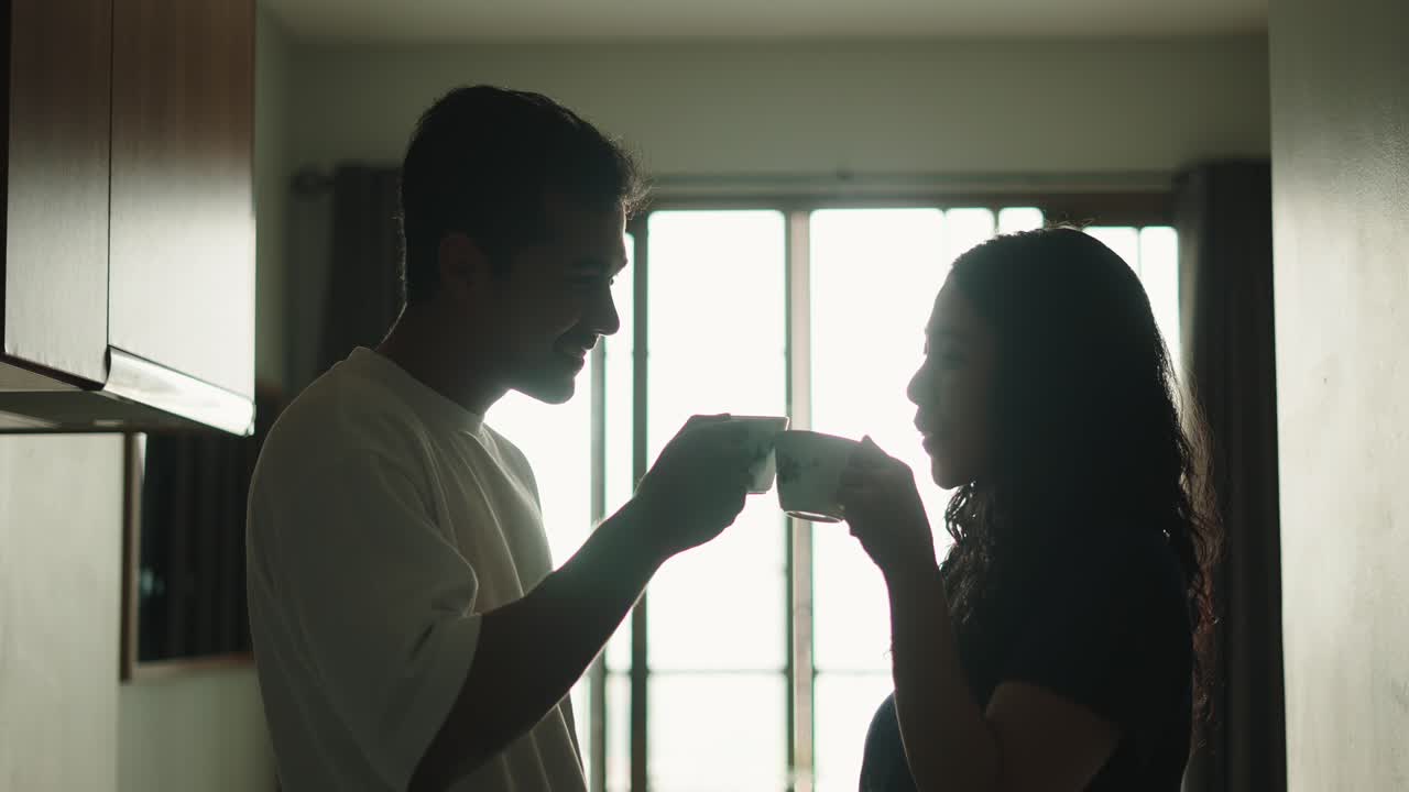 Silhouette of a couple drinking coffee in the kitchen