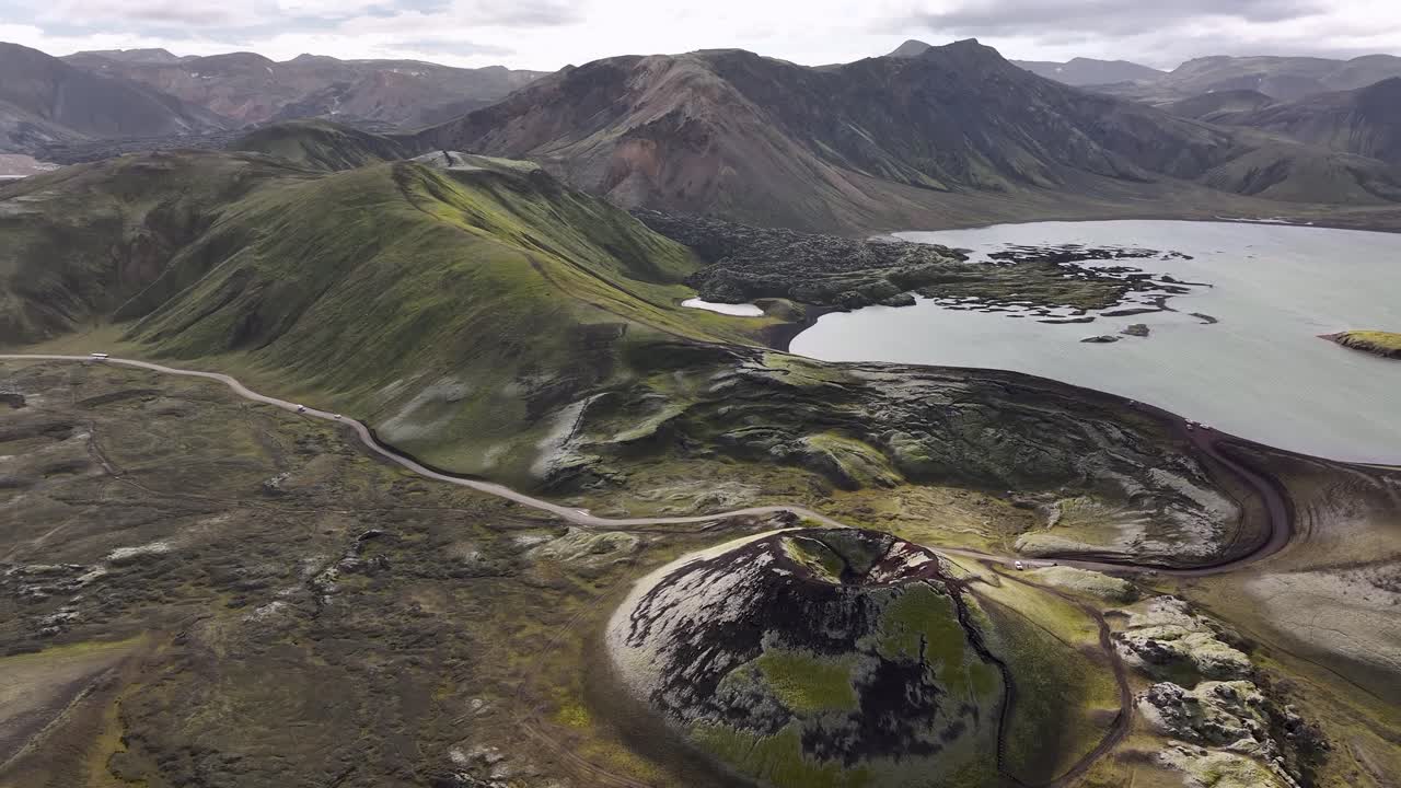 Frostastadavatn Lake With Black Lava Fields And Colorful Rhyolite Mountains In Southern Highlands Of Iceland. Aerial Shot
