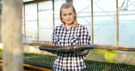 Joven-Mujer-Botánica-Examinando-Planta-En-Maceta-17