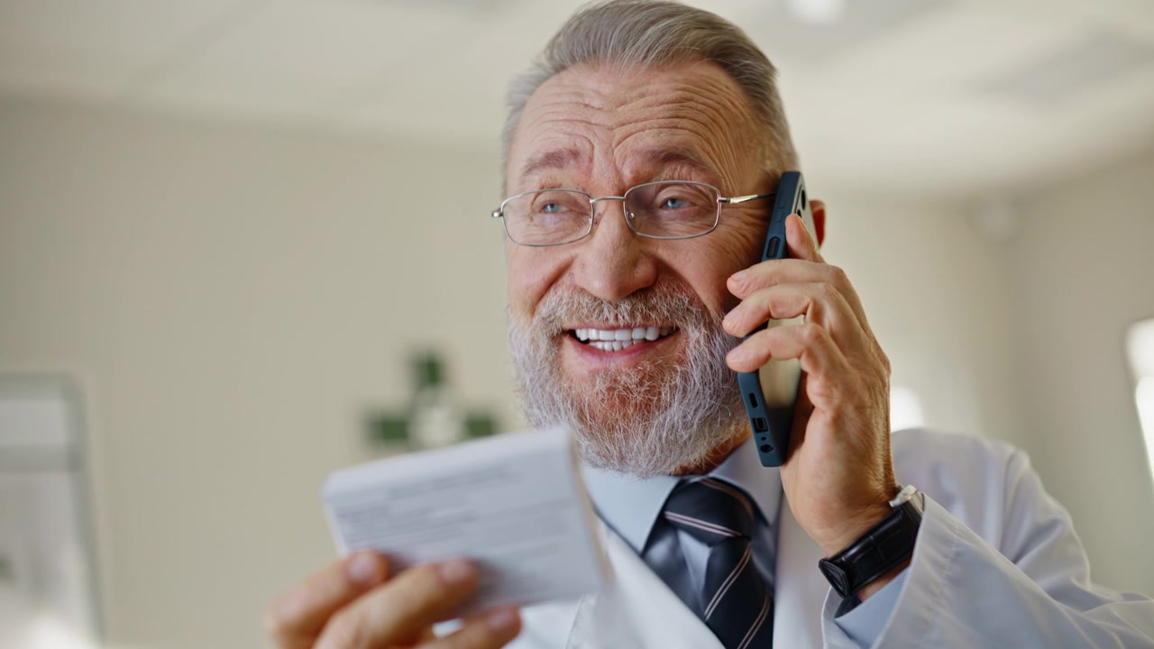 Old pharmacist calling smartphone talking happy face indoors portrait closeup