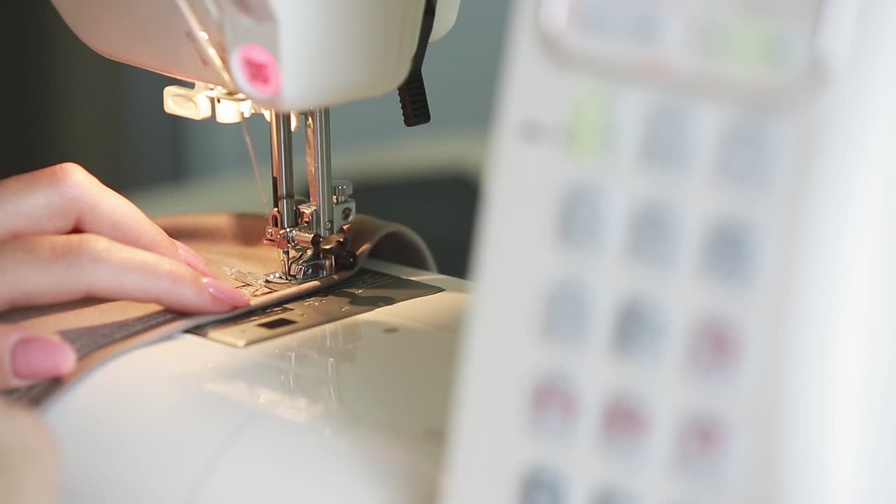 Woman Using a Sewing Machine. Woman stitching fabric using a sewing machine