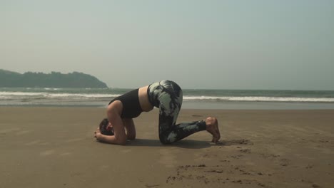 posición de cabeza de yoga asana por mujer joven en la playa al aire libre ejercicio sirsasana