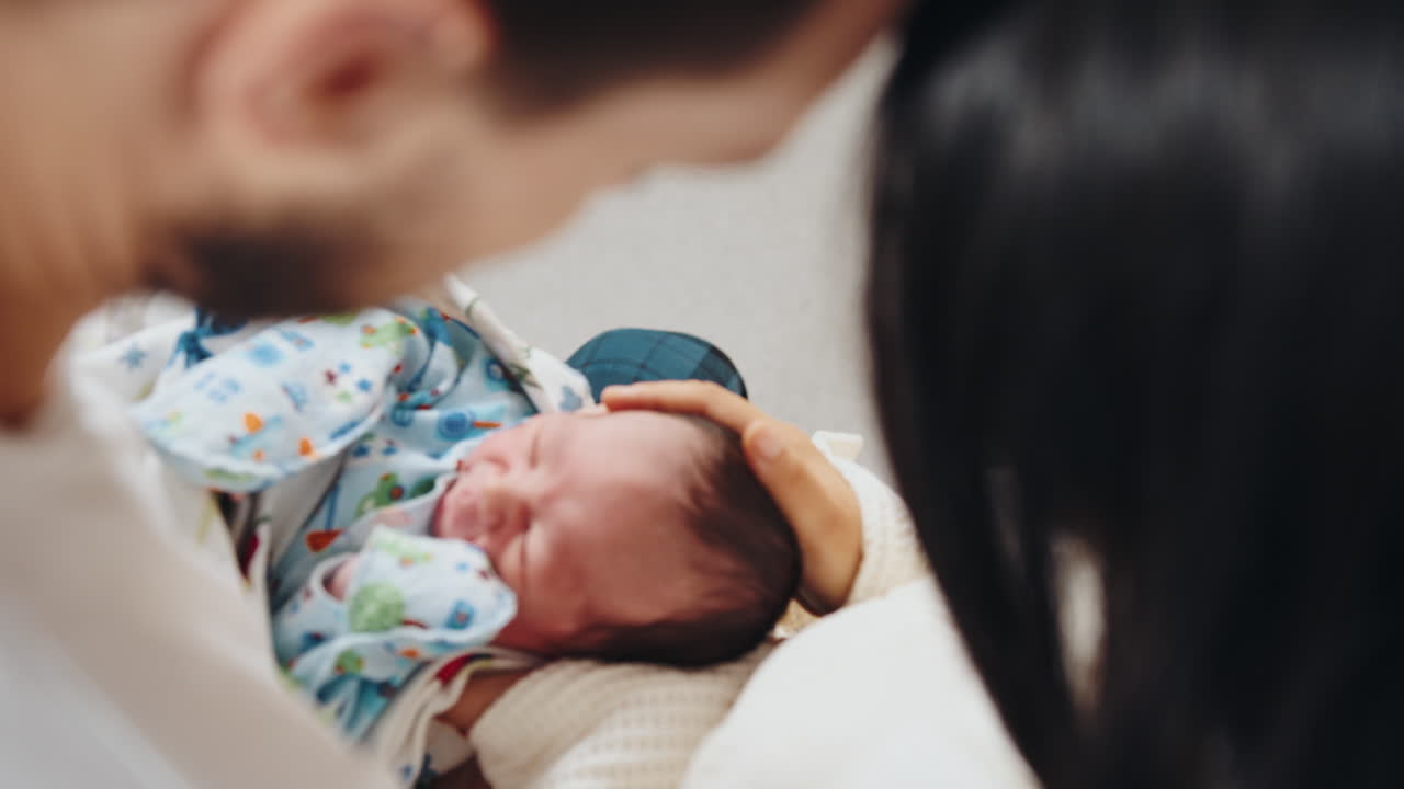 신생아가 부모의 손에 들려 있는 모습