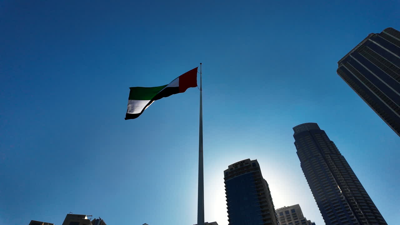 la bandera de los emiratos árabes unidos volando alto sobre el paisaje urbano de dubái