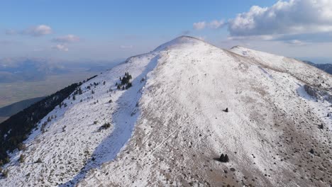 órbita aérea panorámica de las montañas del peloponeso cubiertas de nieve con sombras de lanzamiento de crestas