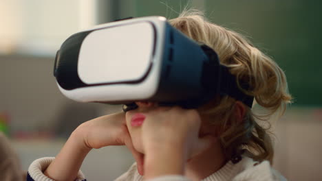 boy wearing 3d vr glasses at lesson. schoolboy immersing in virtual reality