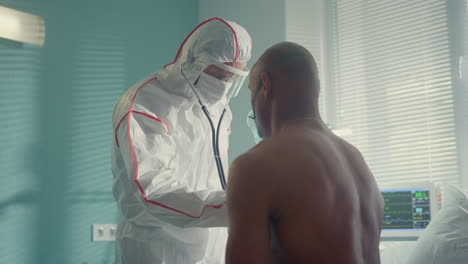 Unknown-doctor-examining-african-man-patient-with-stethoscope-in-hospital.