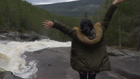 happy girl in the forest by a big waterfall