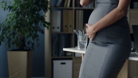 pregnant businesswoman talking on the phone while caressing her belly in the office 1