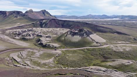 aerial drone view with an orbiting left movement, focusing on stutur crater with the norðurnámshraun lava field on the left, in landmannalaugar