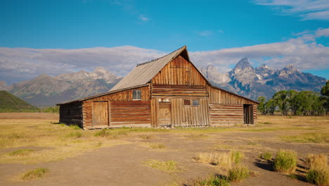 historic wooden barn with grand teton mountains in background
