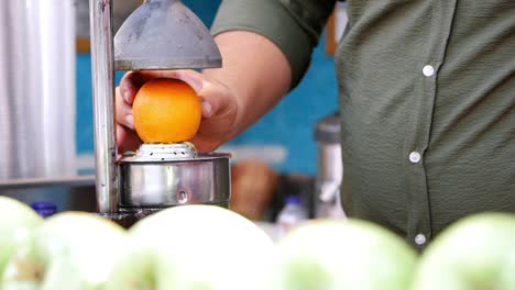 man making orange juice at a street food stall