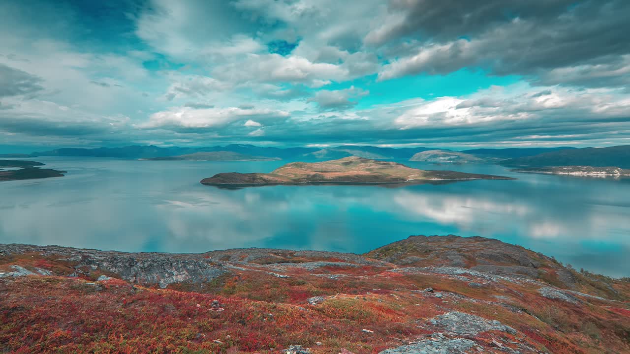 nubes tormentosas sobre el fiordo y el remolino de la tundra en un video de lapso de tiempo iluminado por el sol, creando un marcado contraste con el entorno tranquilo del otoño