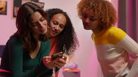 friends looking at a phone in a bedroom