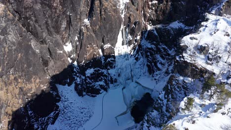 Atemberaubende-Winteraufnahmen,-Die-über-Die-Klippen-Fliegen-Und-Spektakuläre-Gefrorene-Vøringsfossen-Weit-Unten-In-Der-Tiefen-Schlucht-–-Norwegen-–-Freilegen