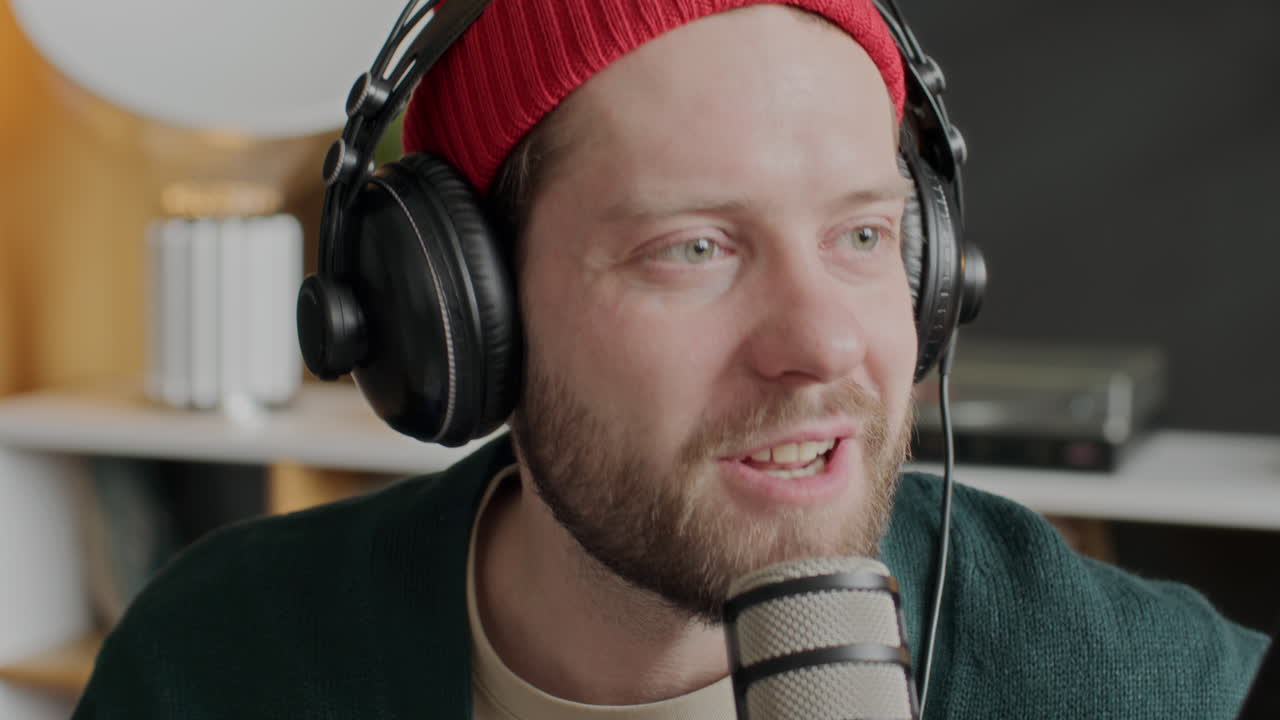 Ung mand taler i mikrofon under podcastoptagelse med medværter