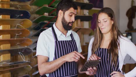 video of diverse female and male sellers with tablet in skate shop