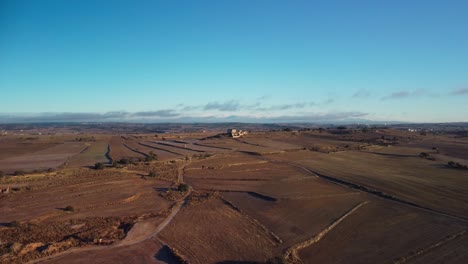 Vast-aerial-view-of-Lleida's-fields-in-Catalonia-during-a-sunny-morning,-expansive-farmlands