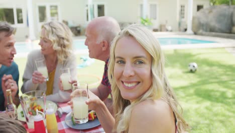 Portrait-of-happy-caucasian-woman-having-dinner-with-family-in-garden