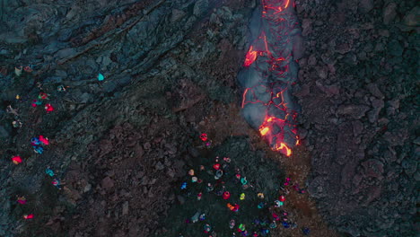 rivers of lava flowing during volcanic eruption in geldingadalir, iceland, people in foreground - aerial top down