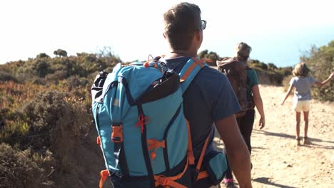 familia de turistas caminando por el sendero en el campo