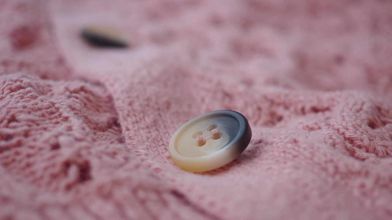 Close-up of a Button on a Pink Knitted Cardigan