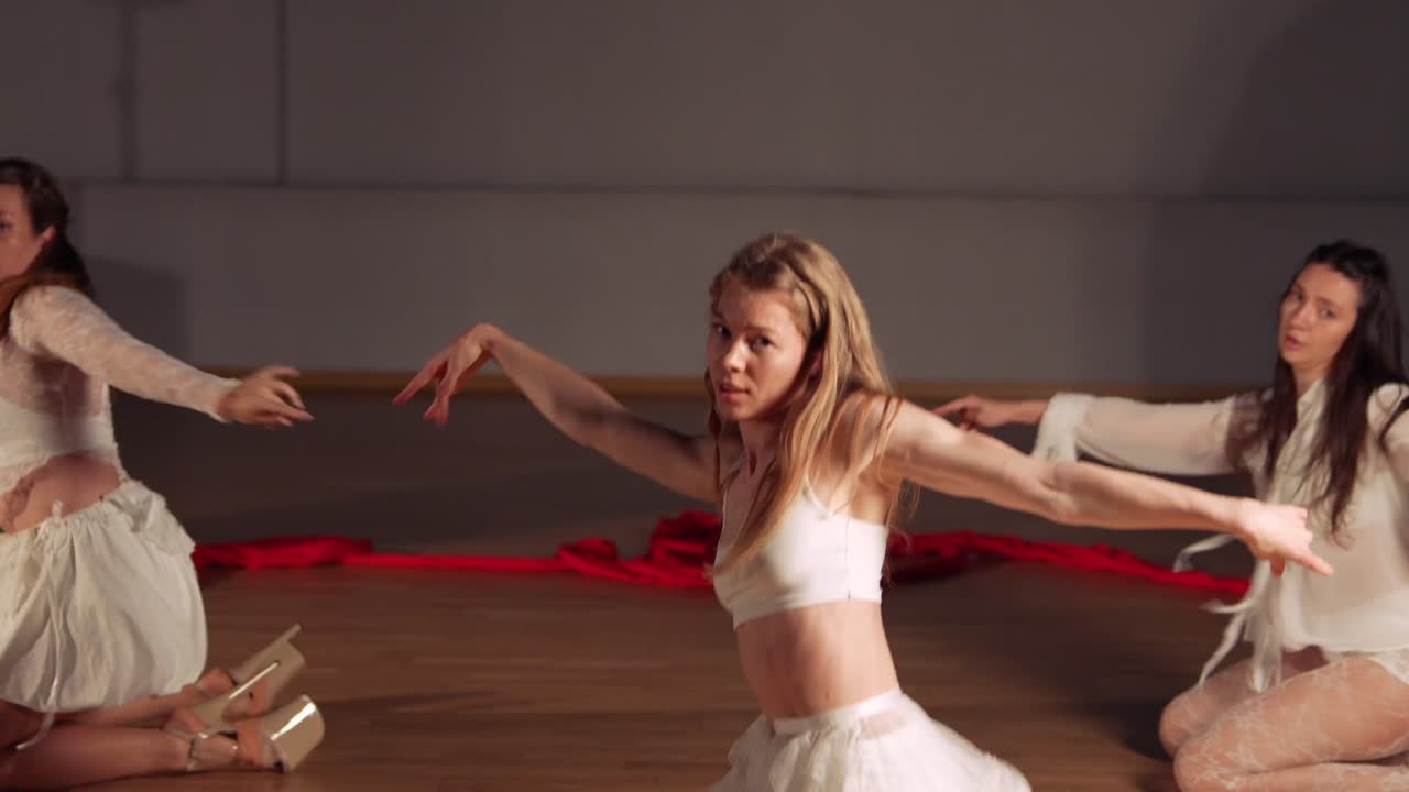 Contemporary Dance Performance with White Dresses and Red Ribbons