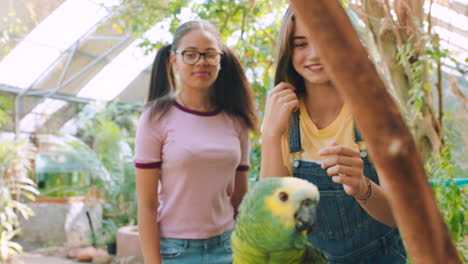 teen girls interacting with a parrot at a botanical garden