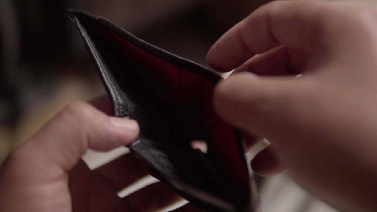 Close up of a person looking into an empty wallet, illustrating financial hardship, lack of cash, budgeting challenges and personal money concerns.