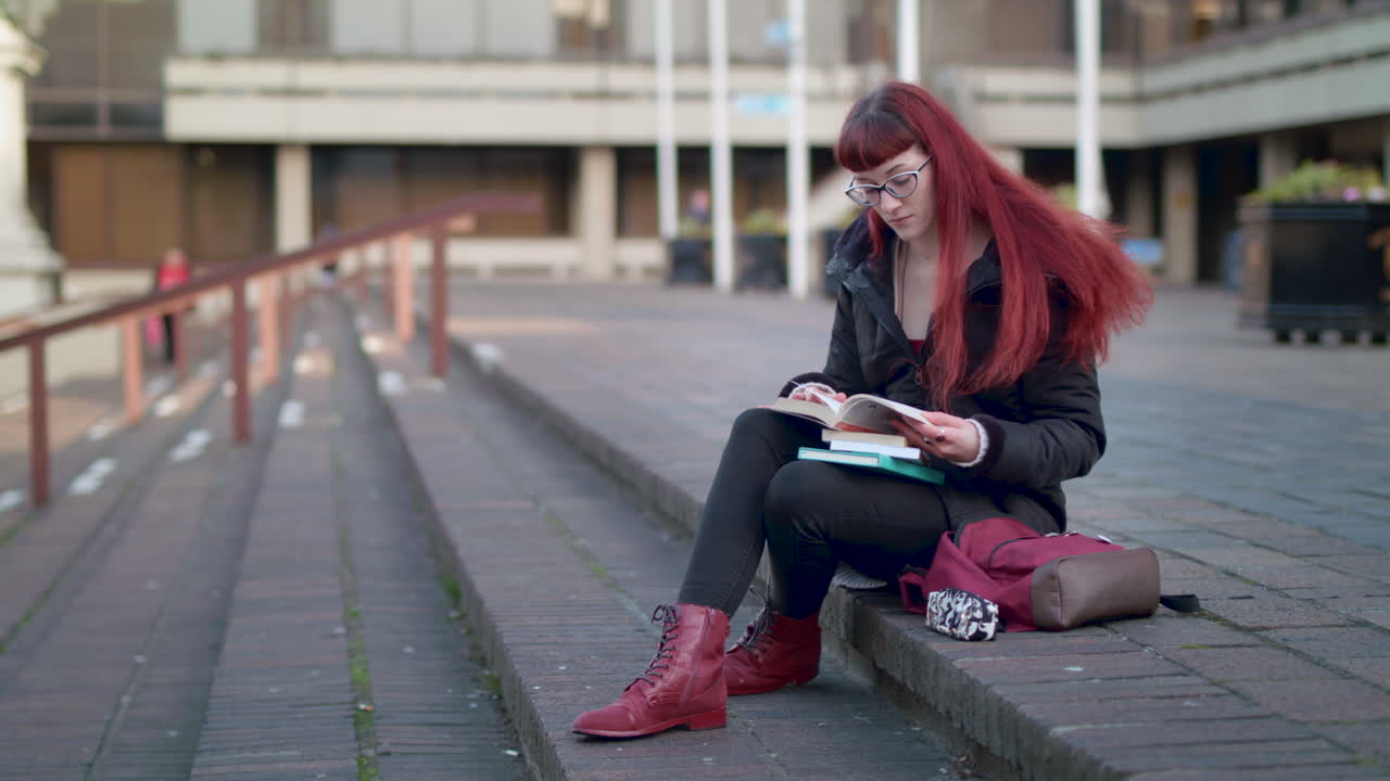 slow motion portriai of a young woman reading outside