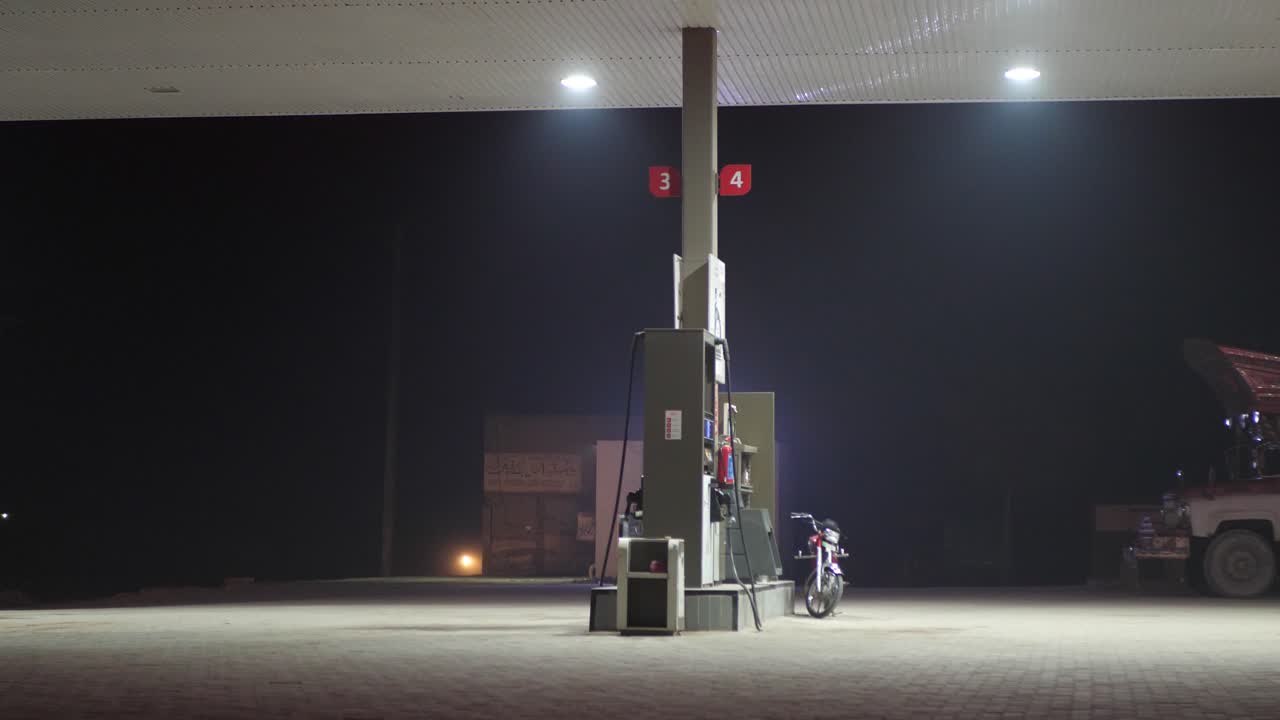 toma de una estación de servicio al lado de una carretera con bicicleta estacionada en la noche en punjab, pakistán
