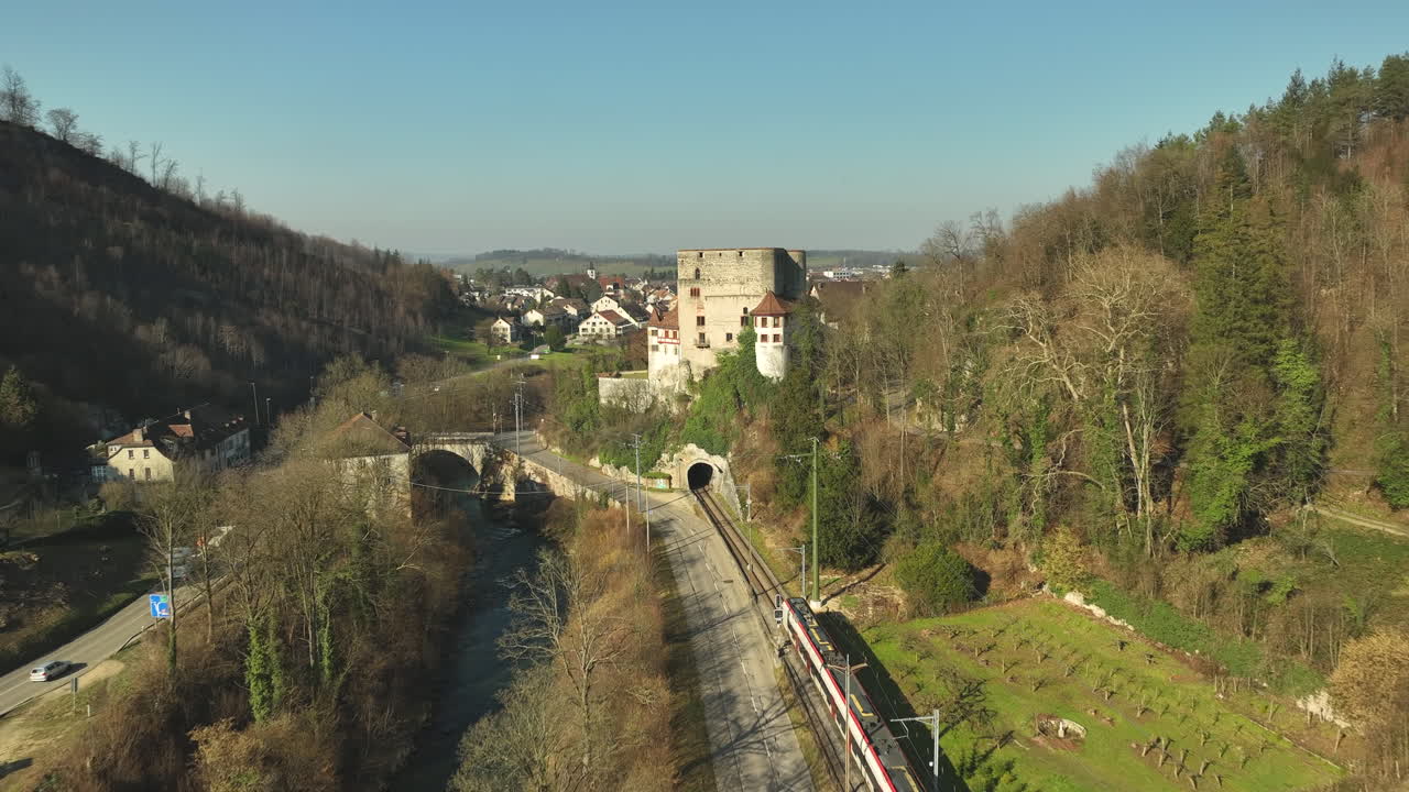 Magnifique château historique d'Angenstein construit sur une colline, tandis qu'un train régional se dirige vers le tunnel par une claire journée d'automne